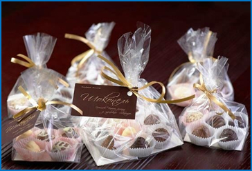 Запаковать конфеты. Подарки в упаковочной пленке. Упаковка конфет в прозрачную пленку. Красиво упаковать конфеты. Конфеты в красивой упаковке.